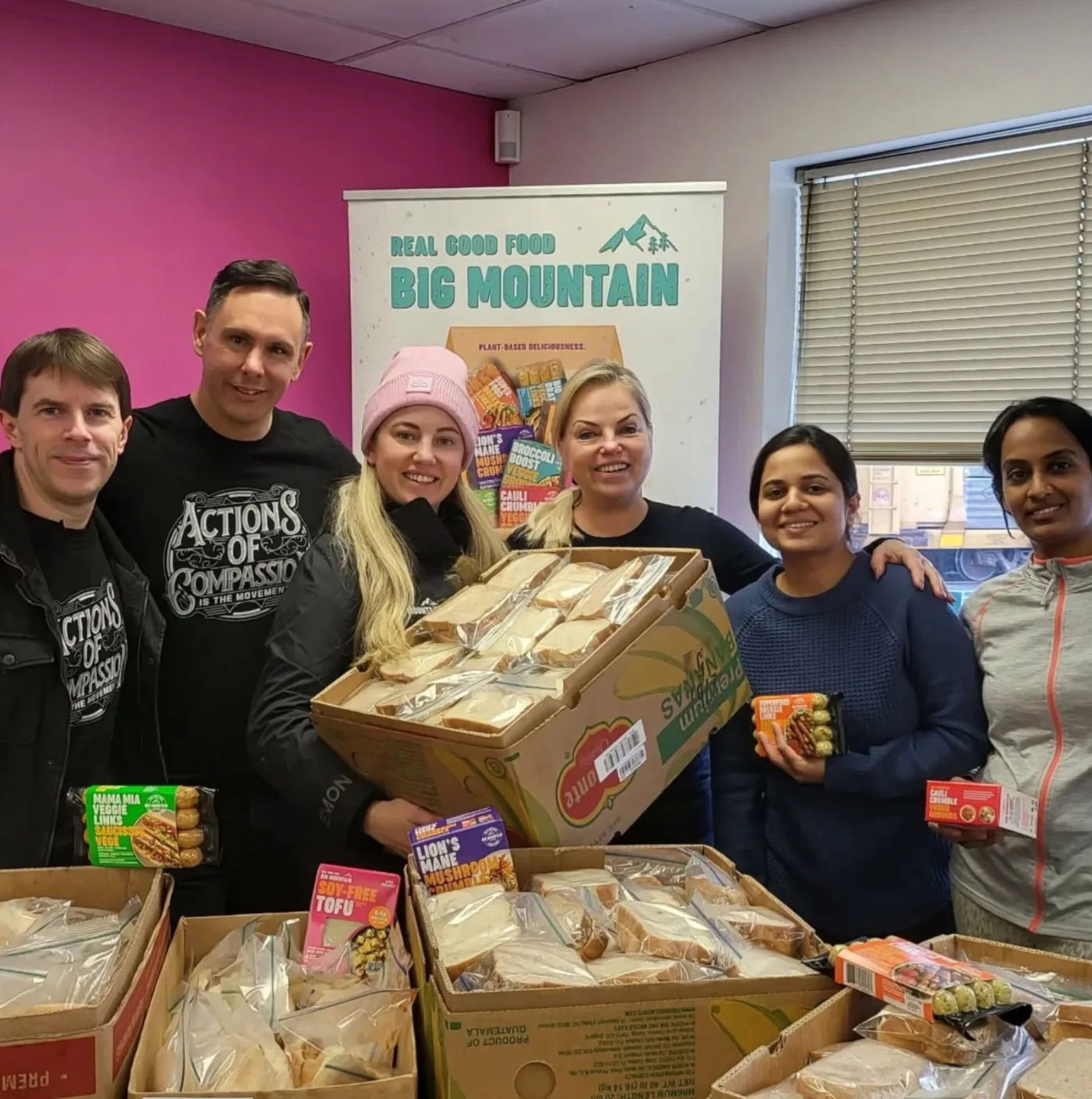 Actions of Compassion volunteers with boxes of donated food at a food drive